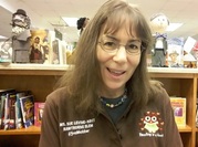 picture of elementary school librarian sitting in front of book shelves